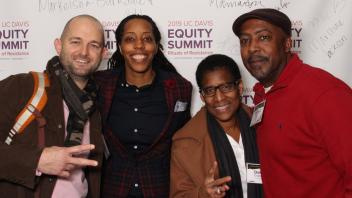 Attendees posing in front of a Equity Summit Banner