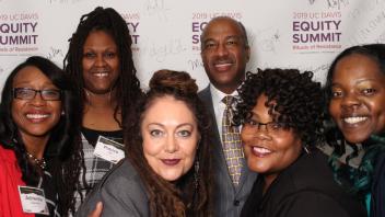 Attendees posing in front of a Equity Summit Banner